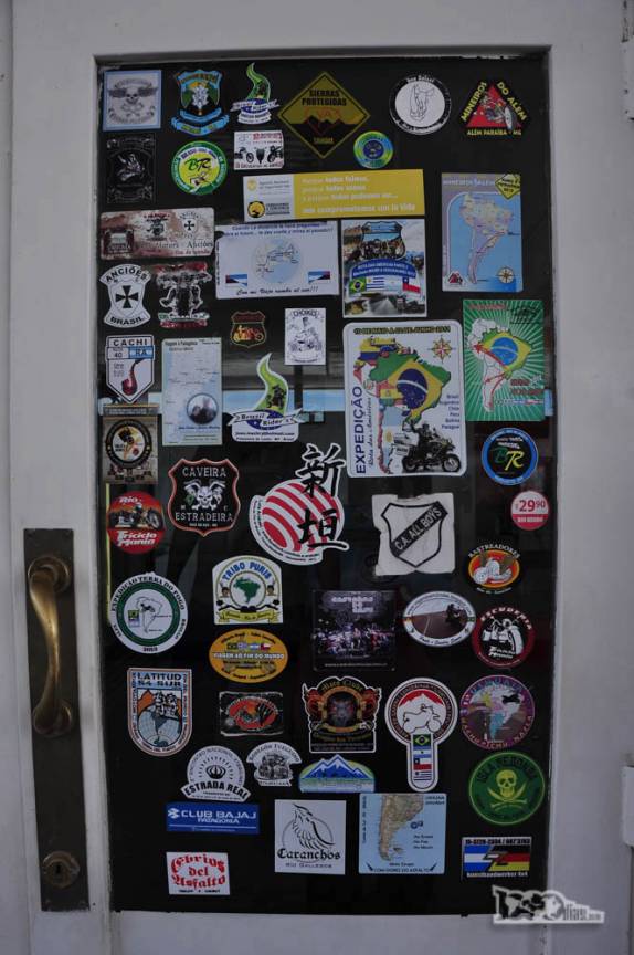 A caminho da Península Valdés, no litoral da patagônia argentina, uma janela de posto de gasolina repleta de adesivos de expedicionários e viajantes